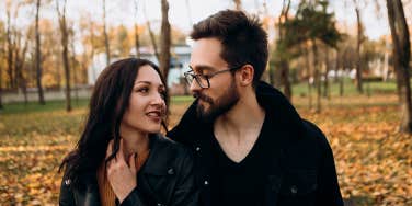 man and woman walking together in park