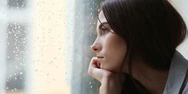 woman looking longingly out window