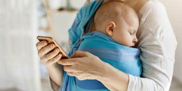 mom carrying baby while on phone