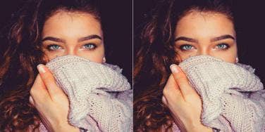 woman covering her mouth with sweater