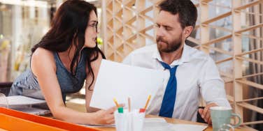 dark-haired woman next to man workplace