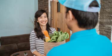 Woman receiving grocery delivery from Uber Eats