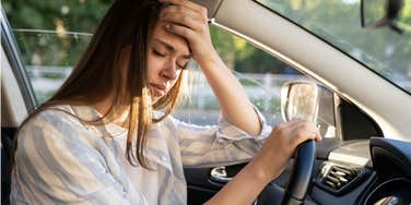 woman experiences nausea and headache while driving