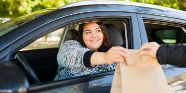 woman picking up food at drive-thru