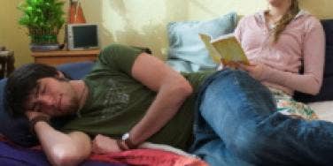 Woman reading while guy sleeps