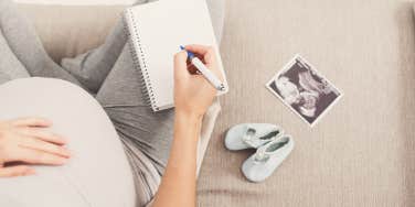 pregnant woman writing down baby names