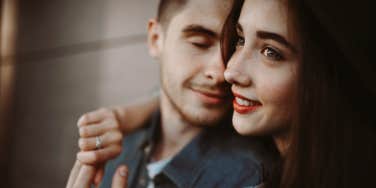 man and woman in their 20s, man looking at woman while she looks away, smiling 