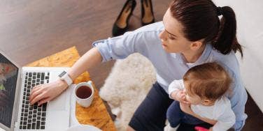 woman working at laptop with toddler on lap