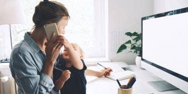 mother working at computer with toddler