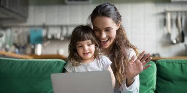 mom waving at computer with daughter on her lap