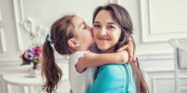 Daughter kissing smiling mom