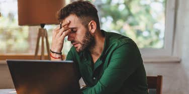 stressed man working at laptop
