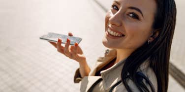 woman smiling while on cell phone