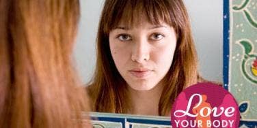 young woman with bangs looking in mirror