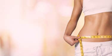 woman measuring her waist