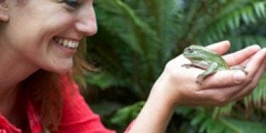 smiling woman holding frog princess prince metaphor