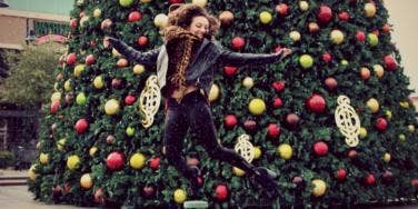 girl jumping in front of christmas tree girl jumping in front of christmas tree