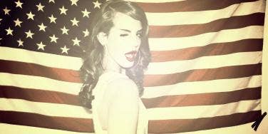 Lana Del Rey winking wearing red lipstick in front of the United States American flag for her "Ride" music video Lana Del Rey winking wearing red lipstick in front of the United States American flag for her "Ride" music video