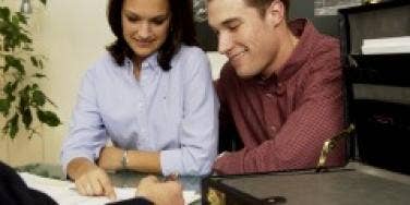Man and woman signing papers in an offce