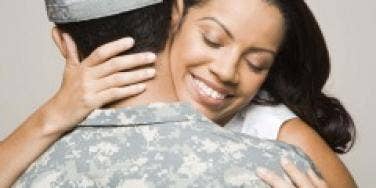 Woman embracing man in fatigues