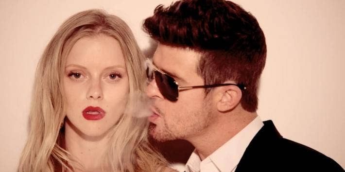 Robin Thicke in Blurred Lines blowing smoke at a blonde model wearing red lipstick
