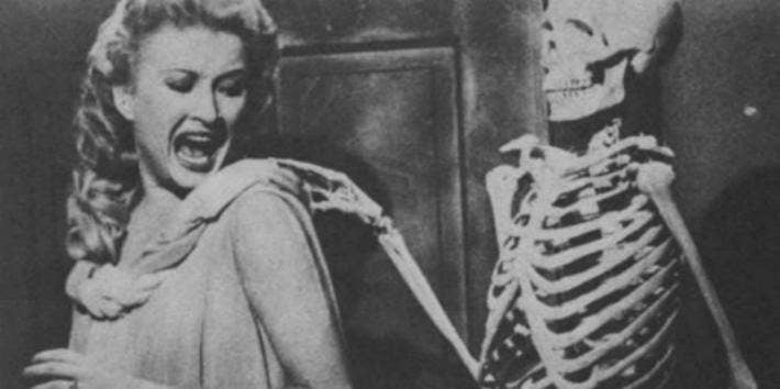 Skeleton touching woman