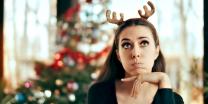 woman with reindeer antlers with christmas tree