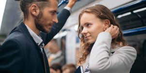 couple standing in a subway daring each other with their eyes