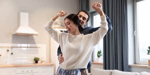 Interracial couple dancing in living room