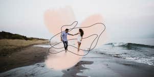 Couple spontaneously running down the beach