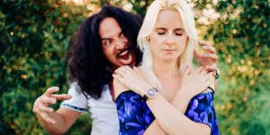 man standing behind woman with annoyance woman in peace