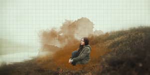 woman sitting alone on a foggy hill 