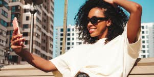 woman taking selfie on bench outside