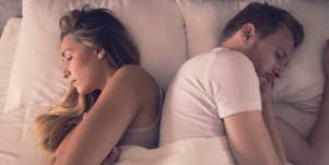 couple facing away from one another in bed