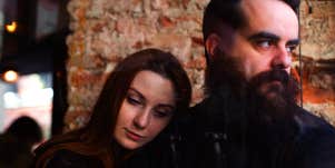 woman leaning on man while sitting at restaurant