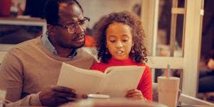 father and daughter reading book