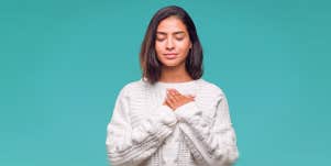 woman holding hands against her heart