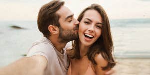 man, kissing a woman, by the beach