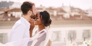 man kissing woman's face
