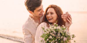 couple hugging, woman holding flower