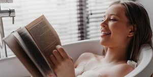girl relaxing reading in bath