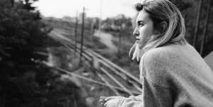 serious woman overlooking train tracks