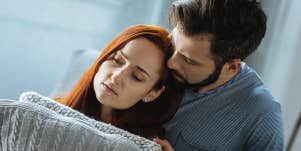 man cuddling woman