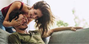 woman covering man's eyes for surprise