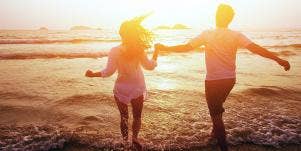 man and woman running into ocean