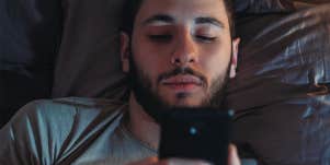 man texting in bed