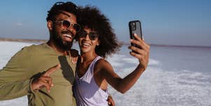 couple taking selfie by beach