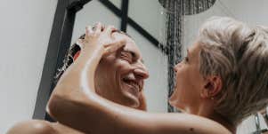woman washing man's hair in shower