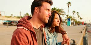 man and woman sitting outside on pier