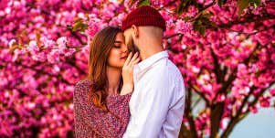 loving couple embracing under pink floral tree
